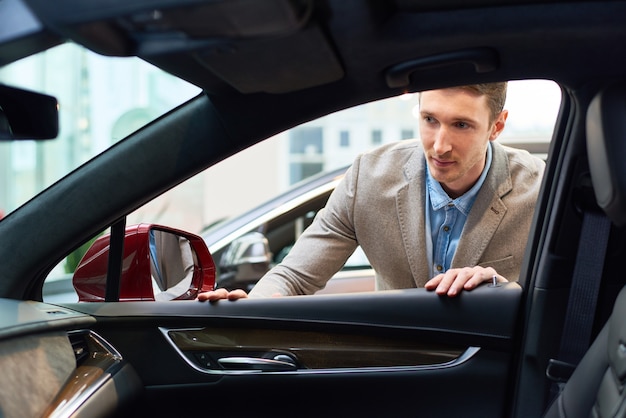 Jeune homme, choisir une voiture à louer