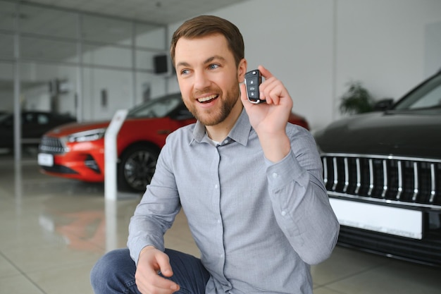 Un jeune homme choisit un nouveau véhicule chez un concessionnaire automobile