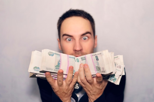Un jeune homme choqué détient un million de roubles en billets de mille dollars. Gagner à la loterie. Le bénéfice de l'entreprise.
