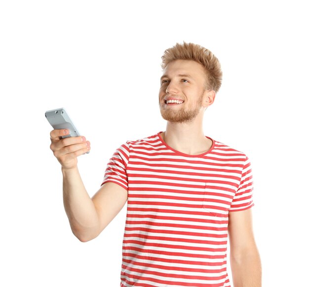 Jeune homme avec climatiseur à distance sur fond blanc