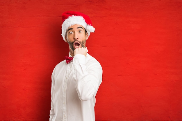 Jeune homme coiffé d&#39;un chapeau de père Noël le jour de Noël