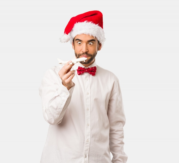 Jeune homme coiffé d&#39;un chapeau de père Noël le jour de Noël