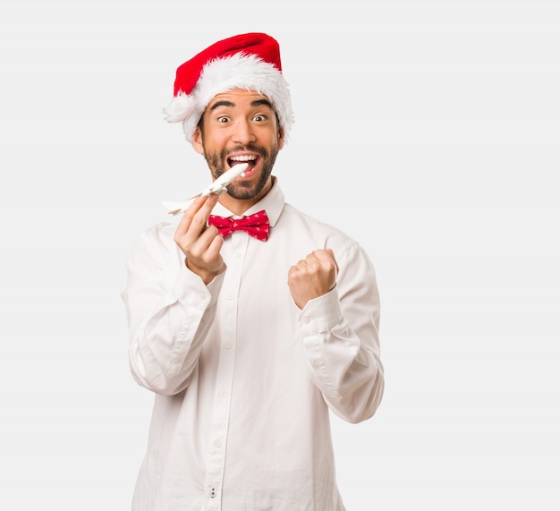 Jeune homme coiffé d&#39;un chapeau de père Noël le jour de Noël