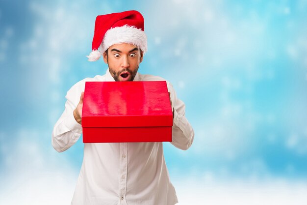 Jeune homme coiffé d&#39;un chapeau de père Noël le jour de Noël