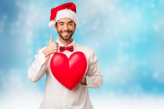 Jeune homme coiffé d&#39;un chapeau de père Noël le jour de Noël