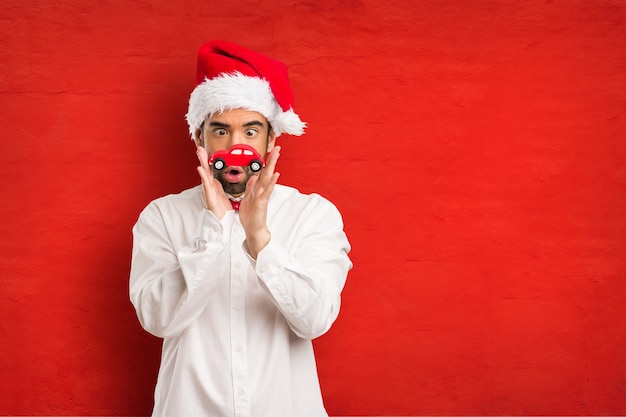 Jeune homme coiffé d&#39;un chapeau de père Noël le jour de Noël