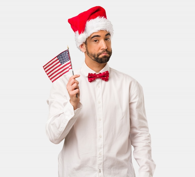 Jeune homme coiffé d&#39;un chapeau de père Noël le jour de Noël