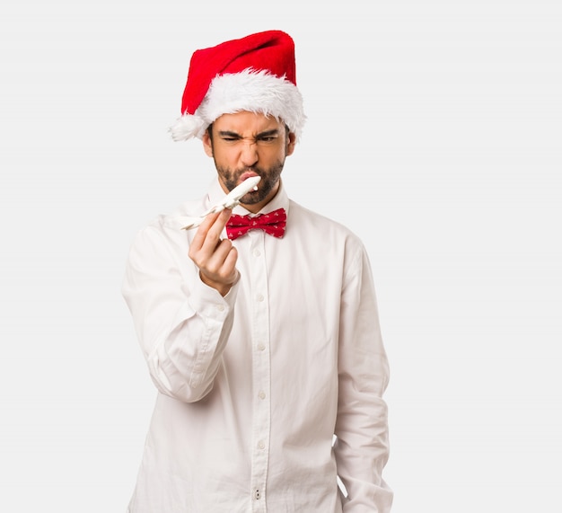 Jeune homme coiffé d&#39;un chapeau de père Noël le jour de Noël