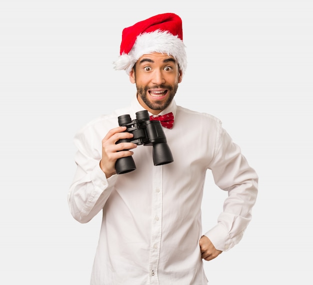 Jeune homme coiffé d&#39;un chapeau de père Noël le jour de Noël