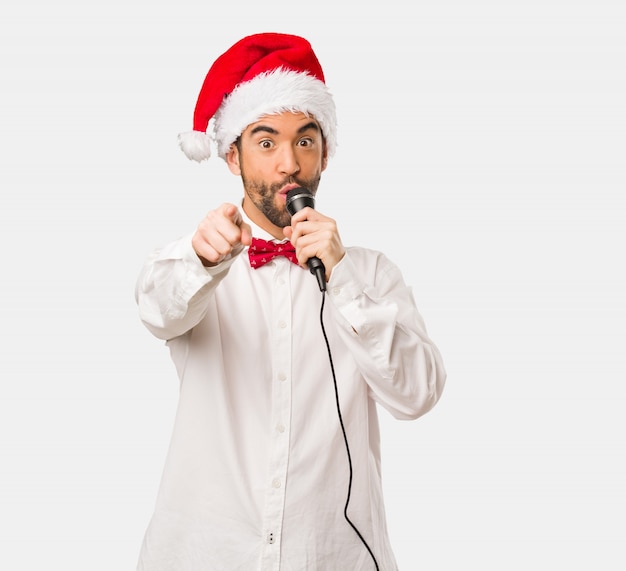 Jeune homme coiffé d&#39;un chapeau de père Noël le jour de Noël