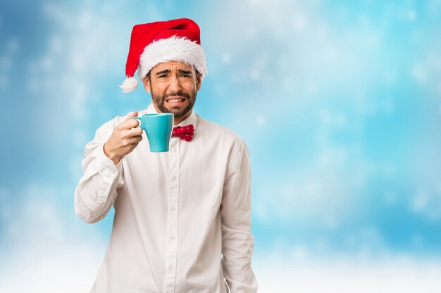 Jeune homme coiffé d&#39;un chapeau de père Noël le jour de Noël