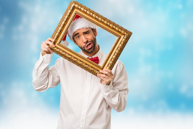 Photo jeune homme coiffé d'un chapeau de père noël le jour de noël