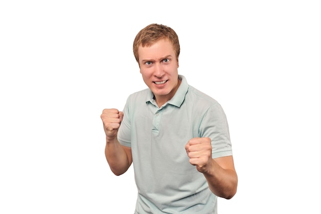 Jeune homme en colère en T-shirt à la menthe prêt à se battre avec les poings isolés sur fond blanc