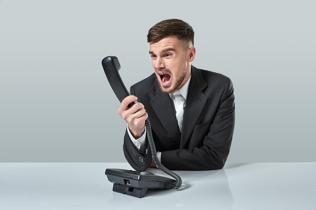 Le jeune homme compose le numéro de téléphone alors qu'il était assis au bureau