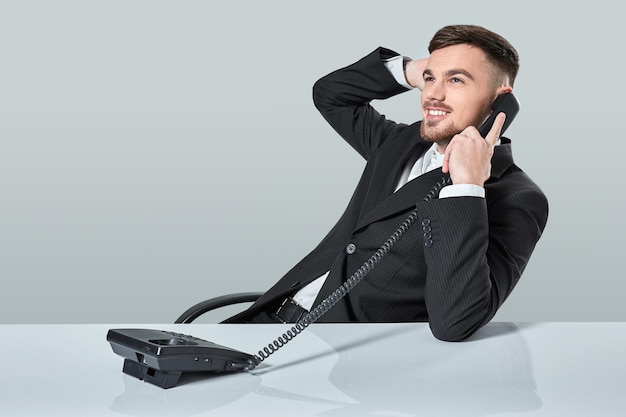 Le jeune homme compose le numéro de téléphone alors qu'il était assis au bureau