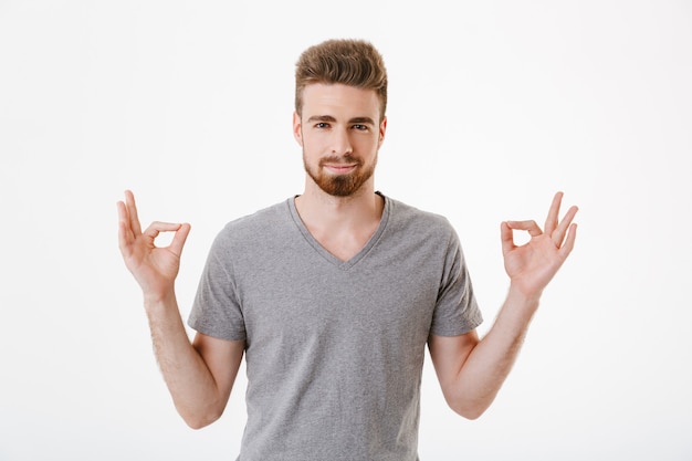 Un jeune homme concentré médite.