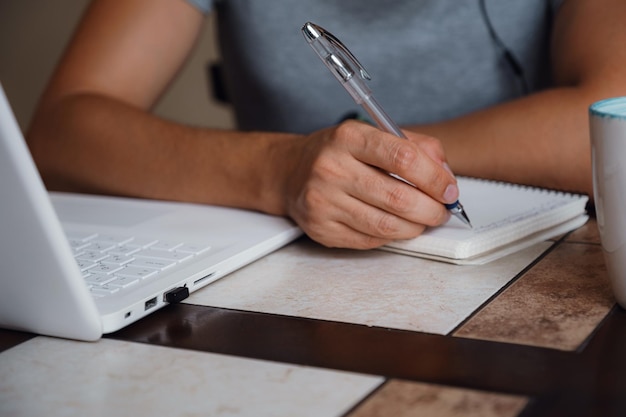 Jeune homme concentré portant des écouteurs étude en ligne