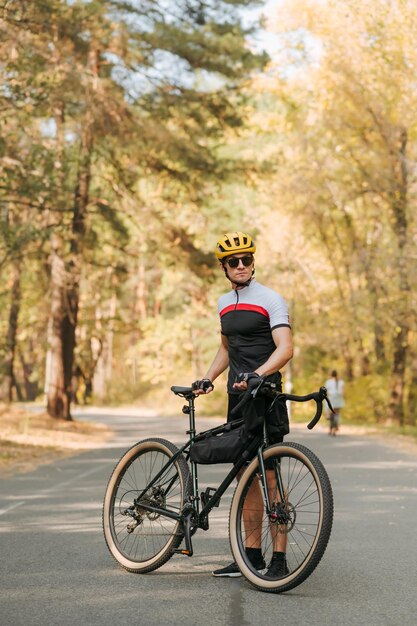 Jeune homme concentré avec un vélo relaxant sur le parc