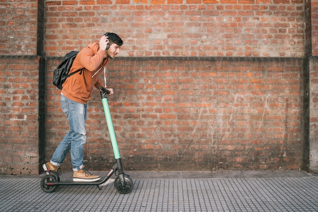 Jeune homme conduisant un scooter électrique.