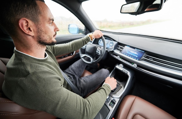 Jeune homme conduisant une voiture moderne