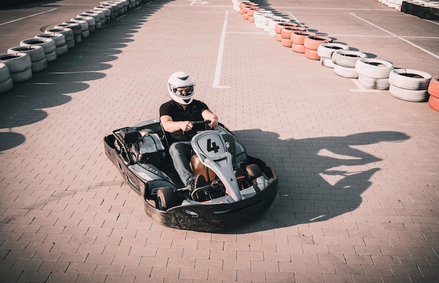 Un jeune homme conduit un kart au circuit