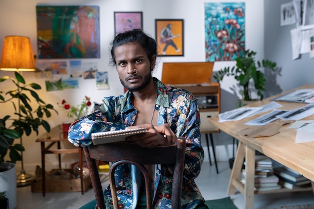 Jeune homme confiant d'origine ethnique indienne travaillant dans un studio d'art