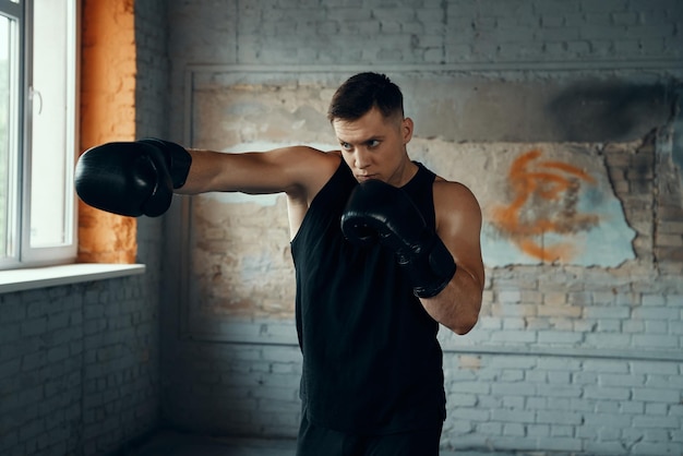 Photo un jeune homme confiant s'entraîne à frapper debout au gymnase.