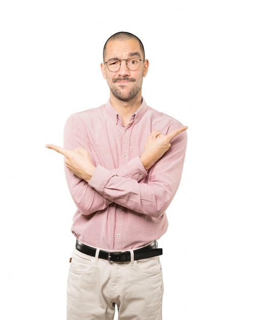 Jeune homme confus poitant dans les deux sens