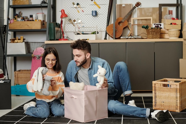 Jeune homme contemporain jouant avec sa petite fille sur le sol du garage