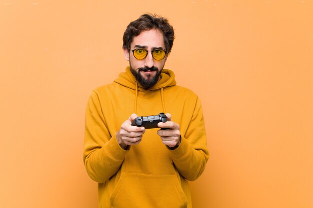 Jeune homme cool fou payant avec un contrôleur de console de jeu