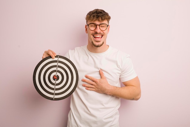 Jeune homme cool riant à haute voix à un concept de cible de fléchette de blague hilarante