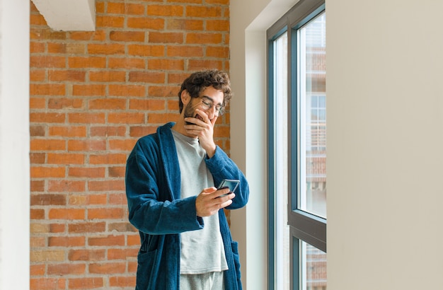 Jeune homme cool se réveiller à la maison en pyjama