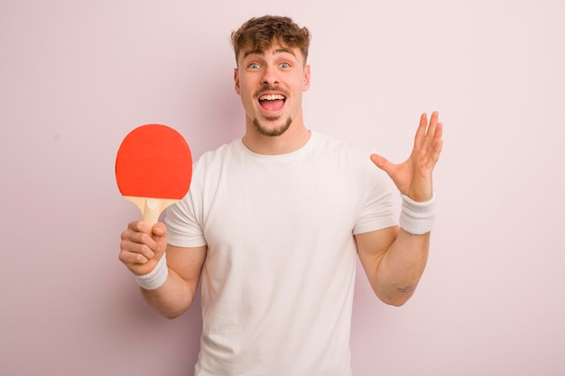 Jeune homme cool se sentant heureux et étonné de quelque chose d'incroyable concept de ping-pong