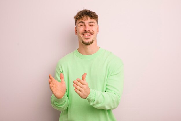 Jeune homme cool se sentant heureux et réussi souriant et applaudissant les mains en disant félicitations avec des applaudissements