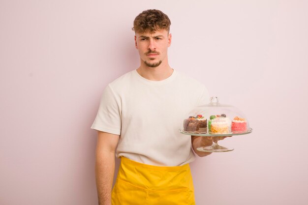 Jeune homme cool se sentant triste bouleversé ou en colère et regardant sur le côté concept de gâteaux faits maison