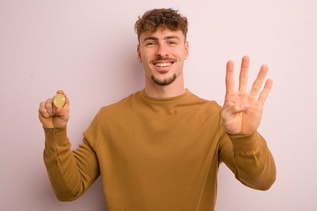 Jeune homme cool souriant et sympathique montrant le concept de bitcoin numéro quatre