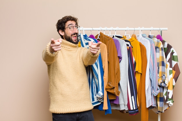 Jeune homme cool avec des vêtements contre un mur plat