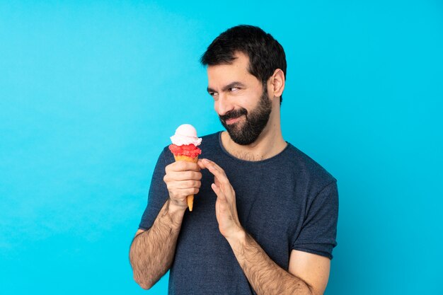 Jeune homme, à, a, cornet, glace, sur, isolé, mur bleu, comploter, quelque chose