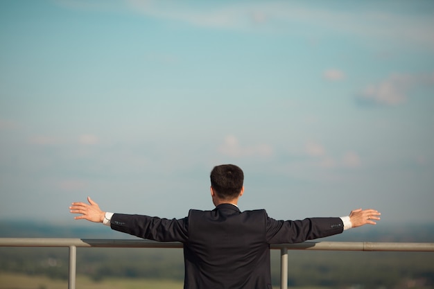 jeune homme en costume debout en été sur le ciel