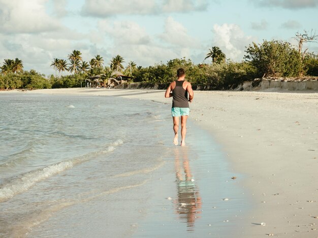 Jeune homme courant le long de la côte de l'océan Atlantique