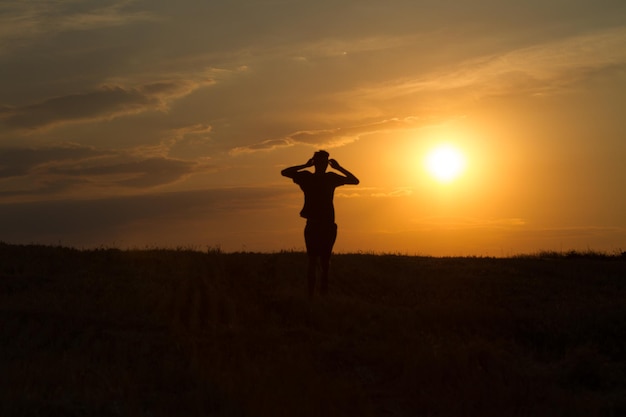 jeune homme courant et montrant le mouvement au coucher du soleil