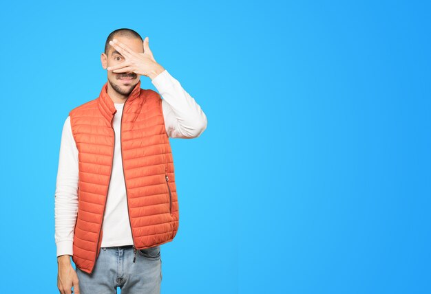 Jeune homme couvrant ses yeux avec ses mains