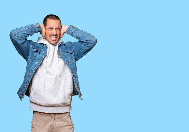 Jeune homme couvrant ses yeux avec ses mains