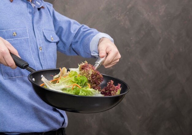 Un jeune homme cuisinant de la nourriture saine dans la cuisine