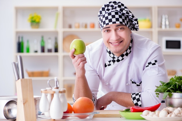 Jeune homme cuisinier travaillant dans la cuisine