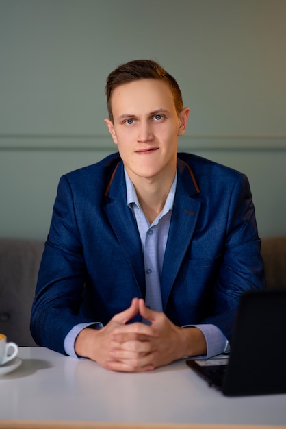 Jeune homme dans un café travaillant sur un ordinateur portable