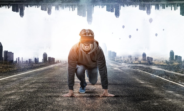 Jeune homme dans un casque VR en position de départ sur une route. Technique mixte