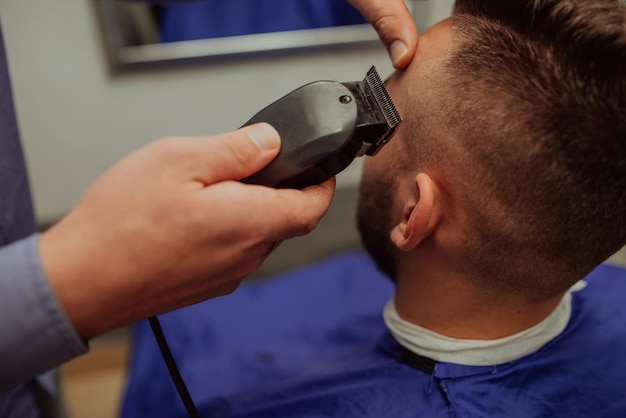 Jeune homme dans le concept de service de soins capillaires Barbershop. Mise au point sélective. Photo de haute qualité