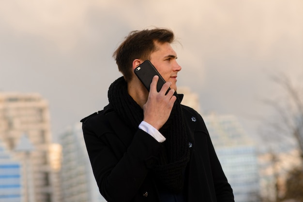 Jeune homme dans la rue avec téléphone mobile