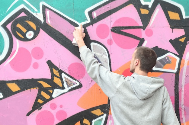 Un Jeune Homme Dans Un Sweat Gris à Capuche Peint Graffiti